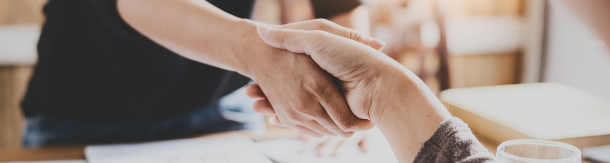 Two people shaking hands in an office.