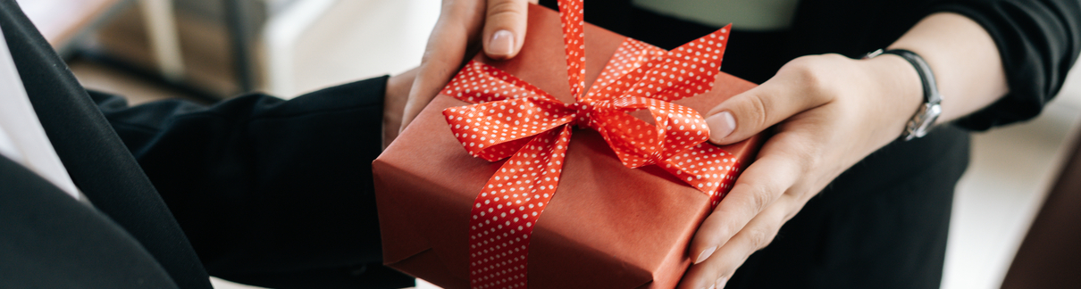 Someone handing a person a wrapped gift.