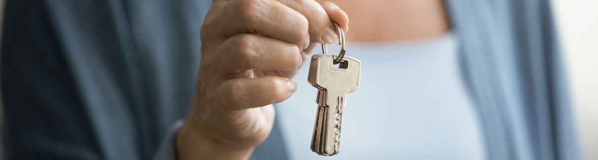 A woman holding up keys.