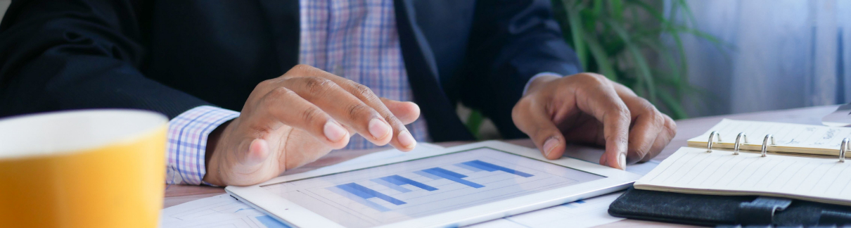 Business man looking at charts on a tablet.
