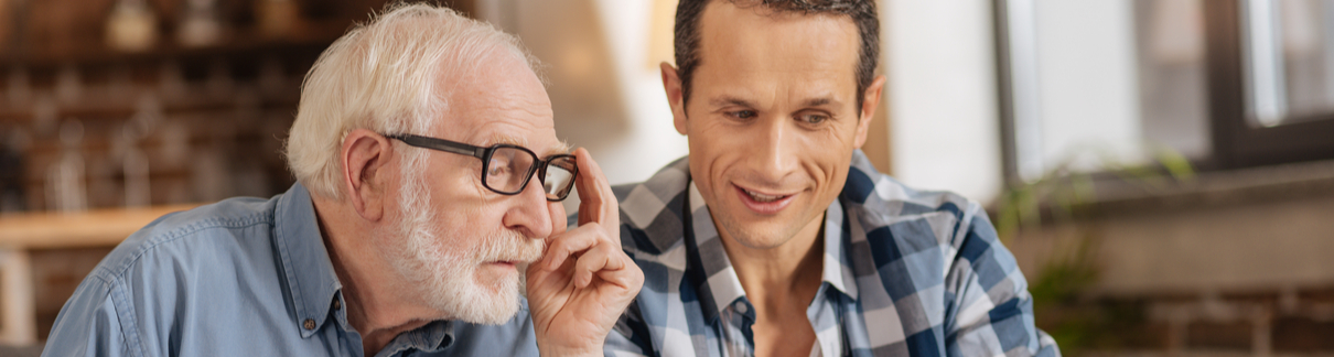 Young man showing his elderly father something on a tablet