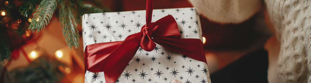 A woman unwrapping a Christmas gift.