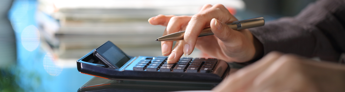 Close-up of a person using a calculator.