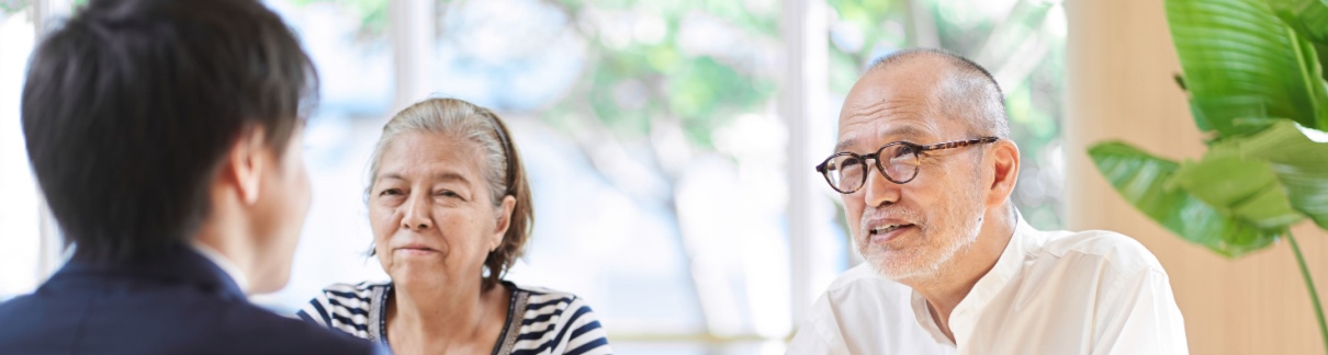 An older couple sits across a table from a younger man.