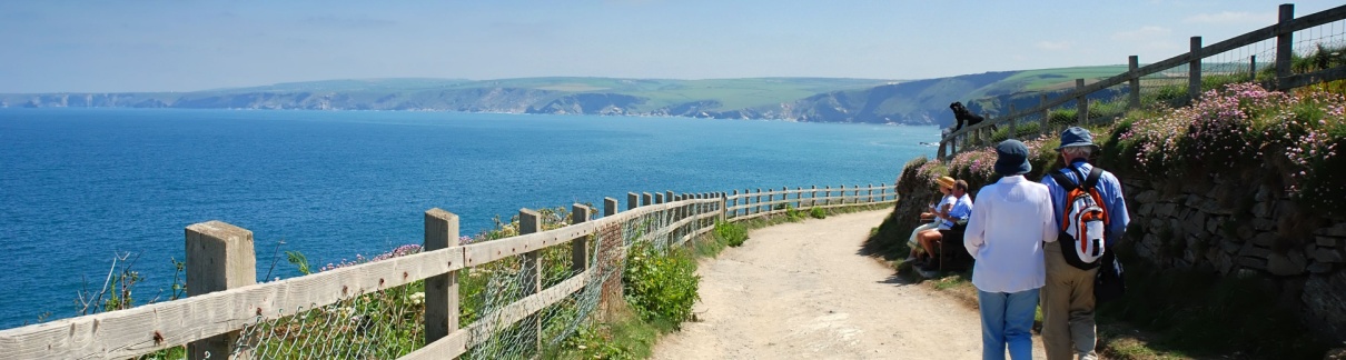 Two people walking along the coast in Port Isaac, Cornwall