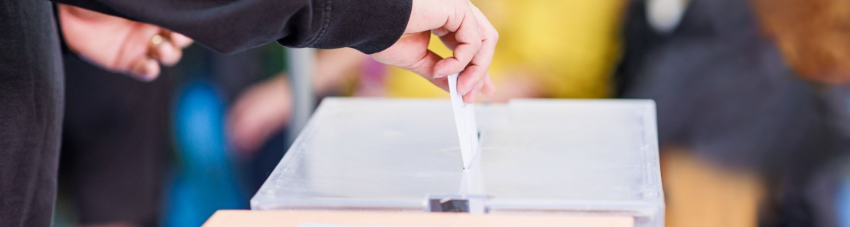 A man voting using a ballot box.