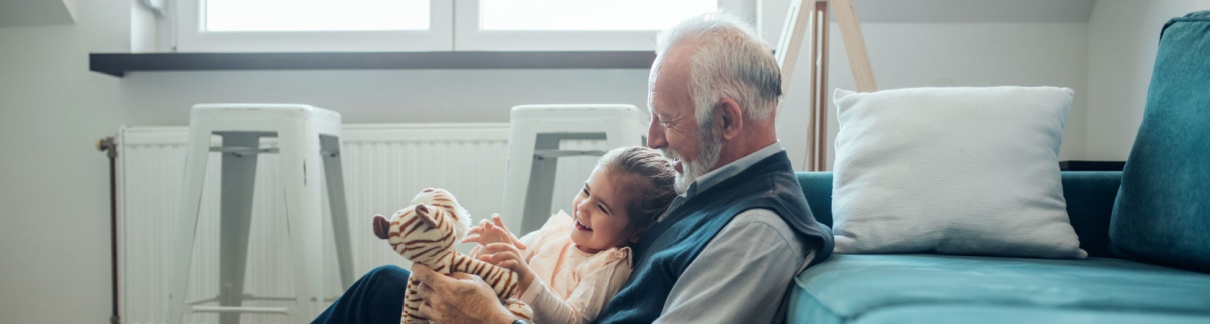 A grandfather playing with his granddaughter.
