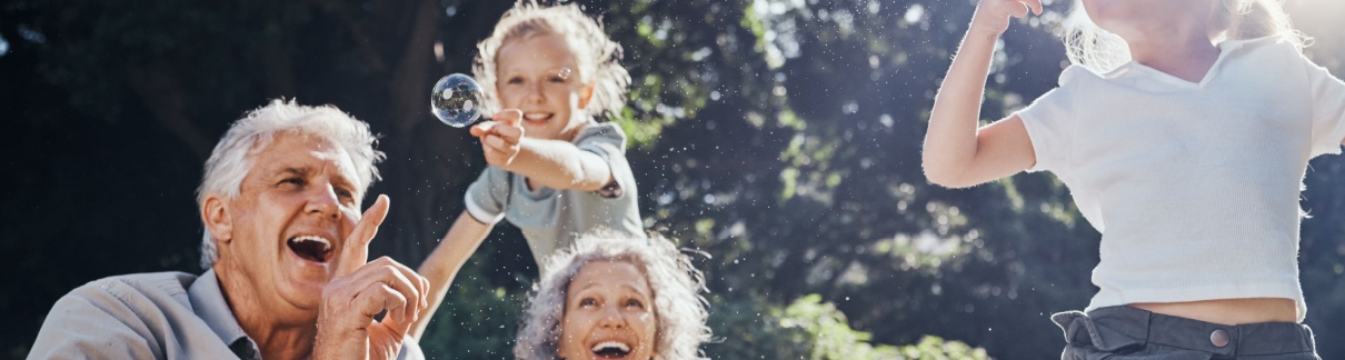 Grandparents blowing bubbles with their grandchildren.