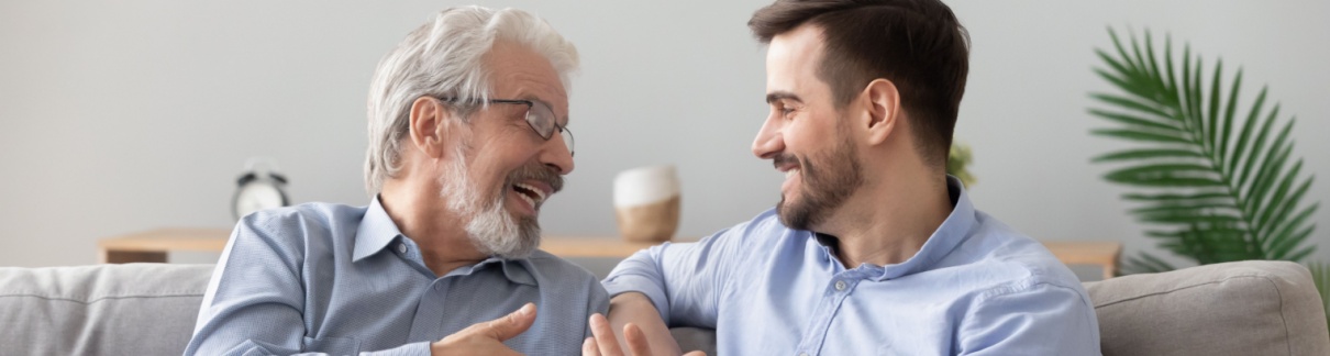 A father and adult son talking together.