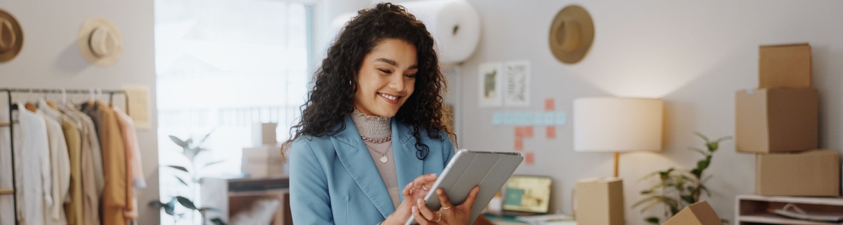 A female business owner using a tablet in an office.