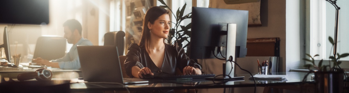 A woman using a computer in an office.