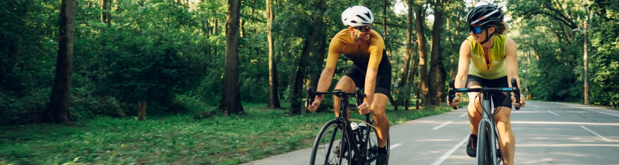 A couple cycling together on a road.