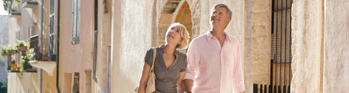 A couple looking at the architecture on an old city street.