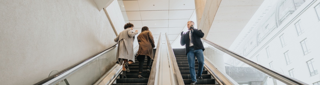 People using escalators in an office building.