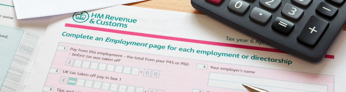 Paperwork relating to a tax return, with calculator and pen lying on it