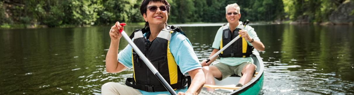 A couple on holiday taking a canoe ride.