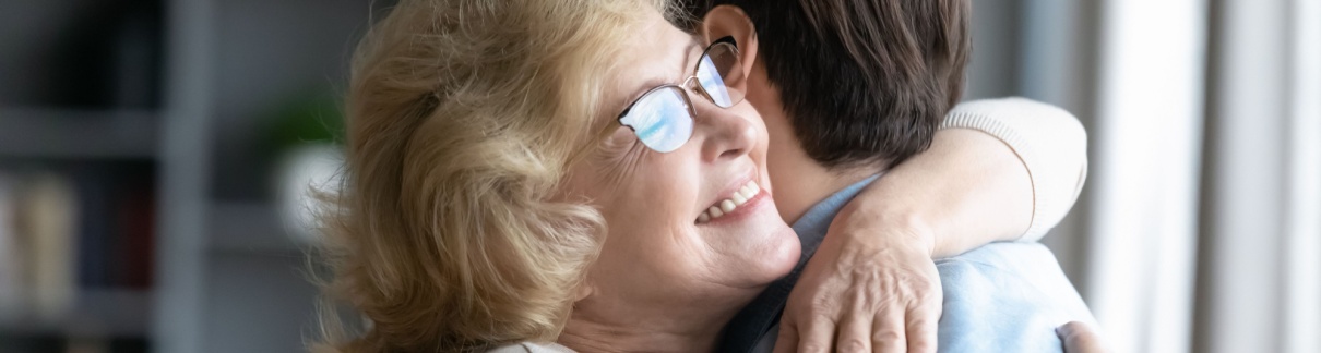A mother hugging her adult son.