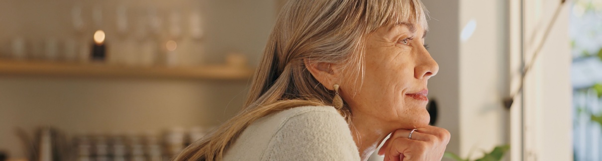 A woman looking out of the window at home.