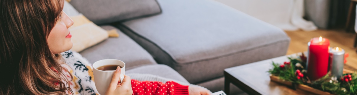 A woman relaxing wearing a Christmas jumper.