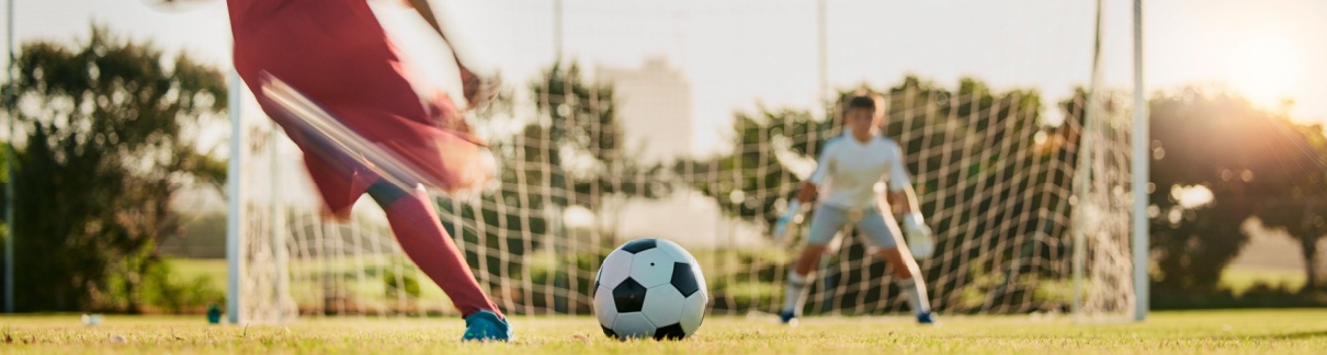 A footballer taking a shot at a goal.