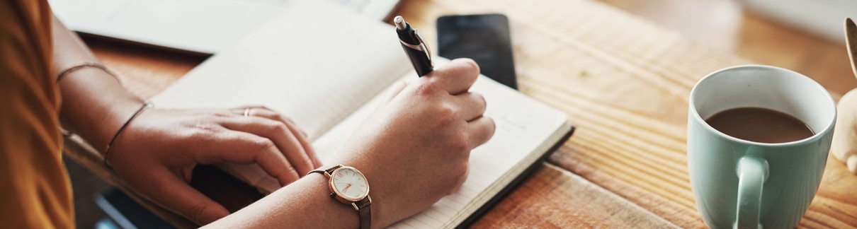 A woman making notes in a diary.
