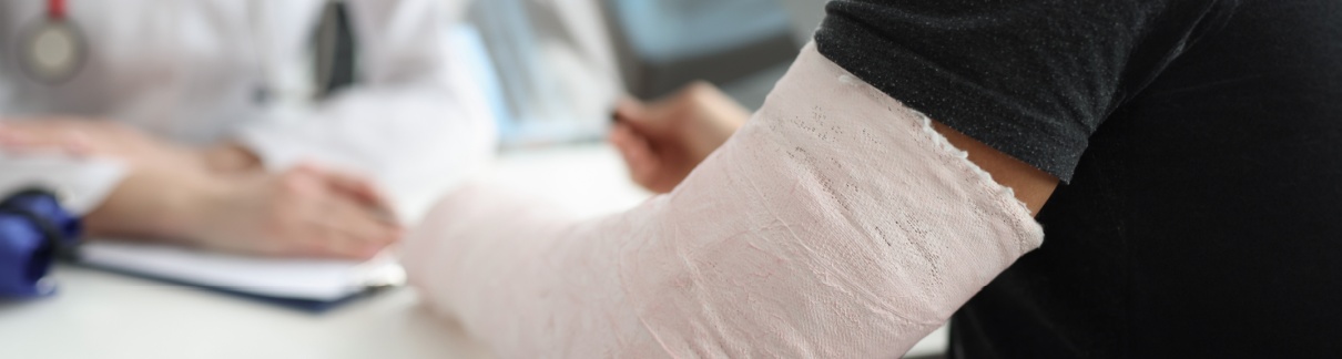 A man with a broken arm speaking with a doctor.