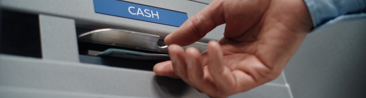 A person using an ATM to withdraw cash.