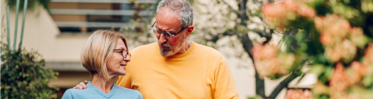 Mature couple walking outside a house