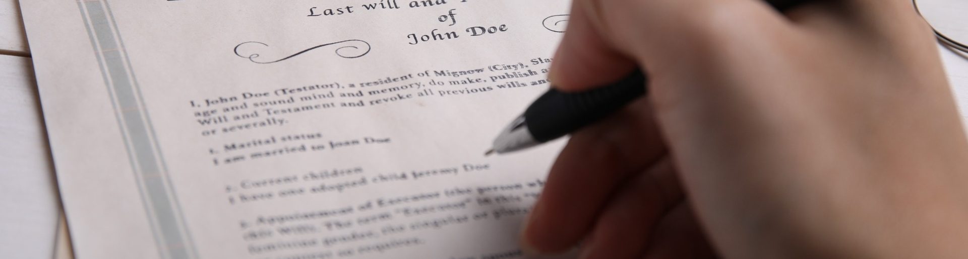 A person signing a will.