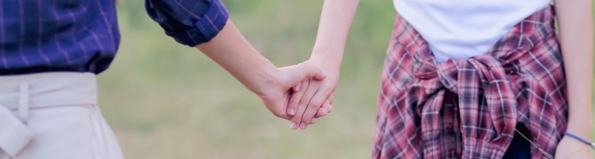 Two women holding hands.