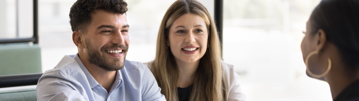 An estate agent shaking hands with a couple.